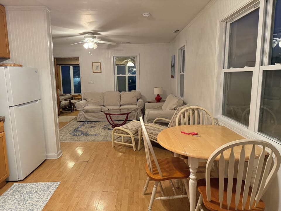 kitchen drop-leaf table, 5 matching chairs, open family room, front porch beyond