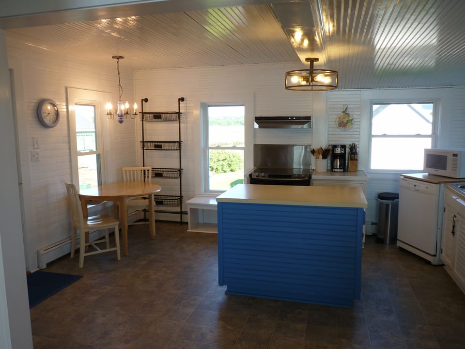 Kitchen from dining room with small table overlooking the marsh