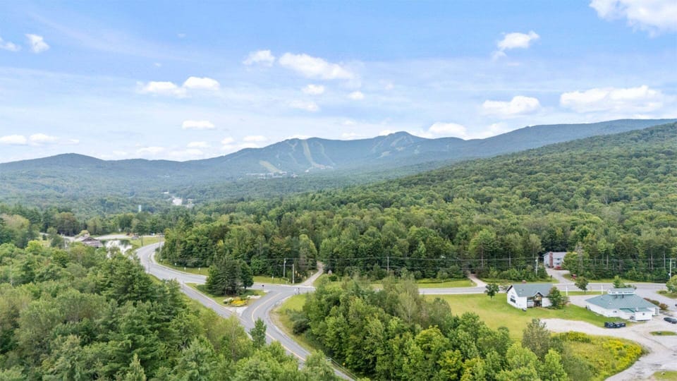 This summer aerial shows Killington's green slopes rising beyond the neighborhood.
