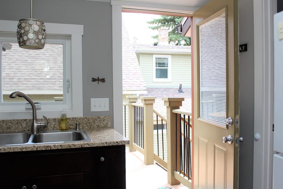 Kitchen leading to outdoor entrance with shared deck