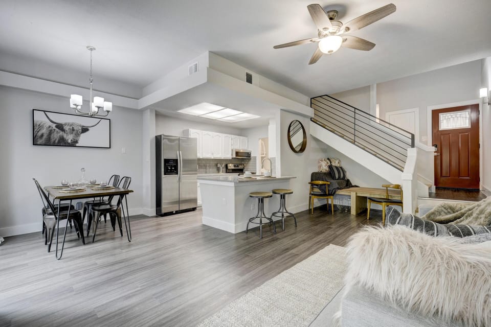 View of living room, kitchen dining room. There is a single platform bed.