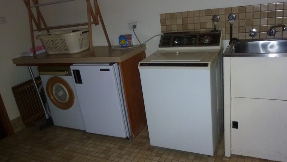 Downstairs laundry with washing machine, sink, dryer and small chest freezer