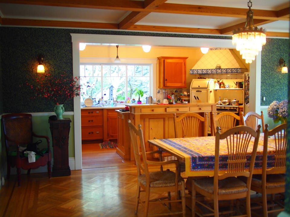 Dining room with kitchen in background.  Kitchen has large island.