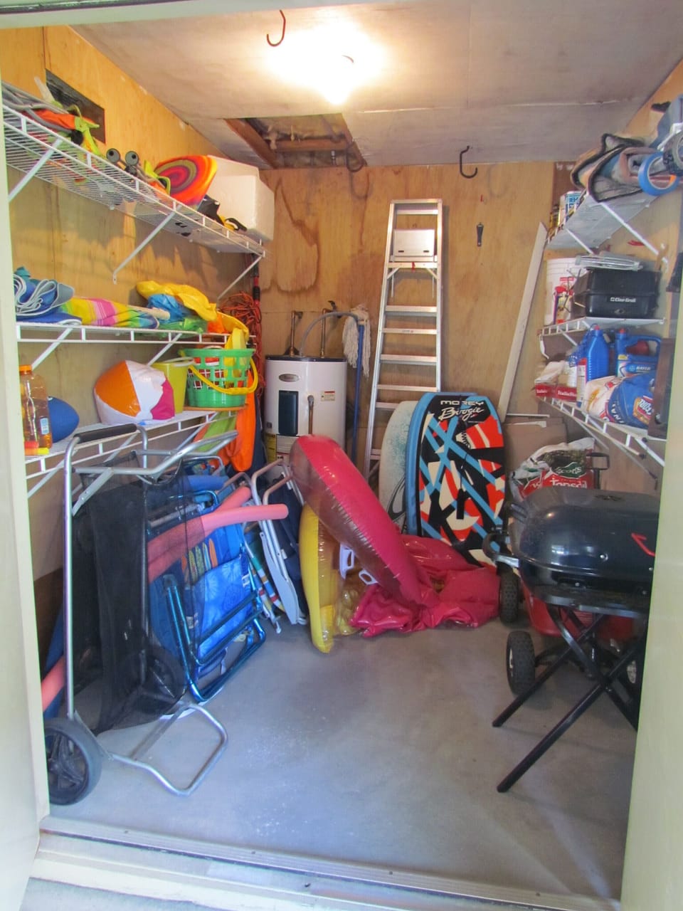 This is the utility closet with chairs and beach items and a charcoal grill.