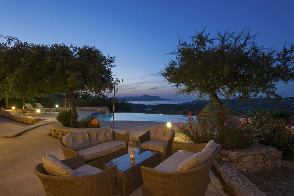 Villa Prinolithos poolside lounge area at sundown.
