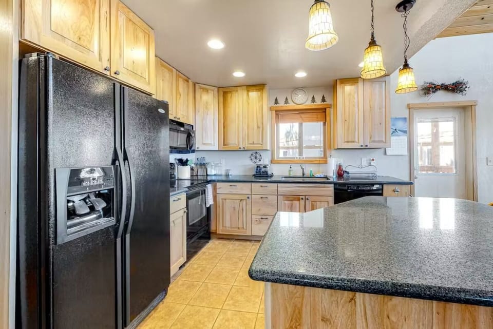 Well appointed kitchen with island and bar stools.