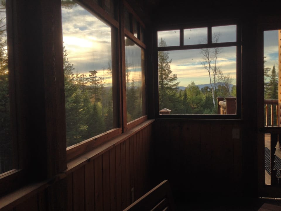 Mountain views from screened porch with patio table and outdoor speakers.