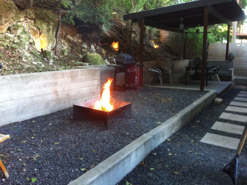 Private backyard terrace faces a rock wall formed by a natural fault line
