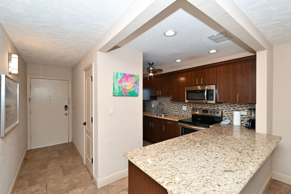 Modern, renovated, fully equipped kitchen with granite counters, glass tile backs splash...
