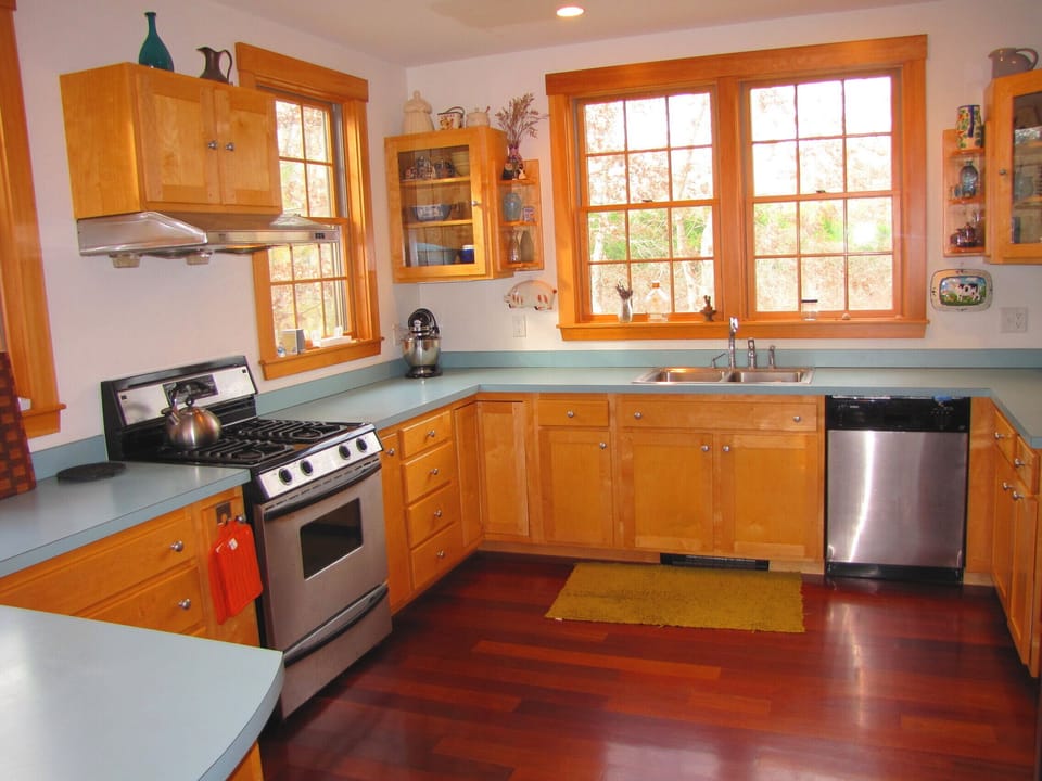 Open kitchen with eat-in bar, opens to porch and dining and living rooms