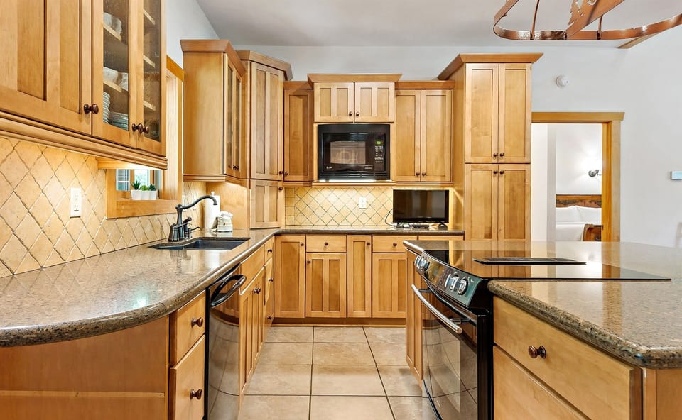 In addition to the smooth-top range, dishwasher with hidden controls, and microwave, there is a TV