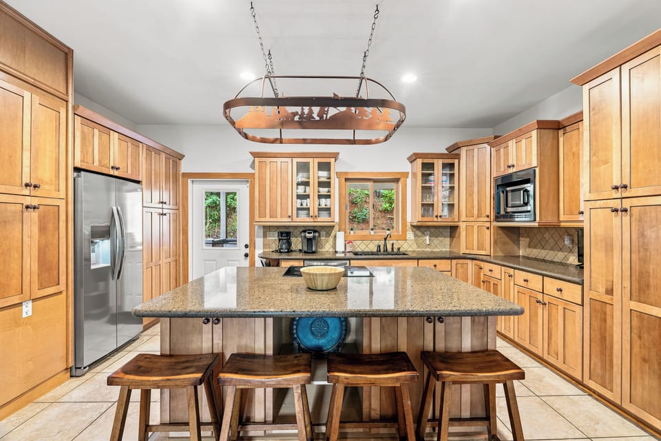The center island has a beautiful granite counter and a breakfast bar with seating for 4