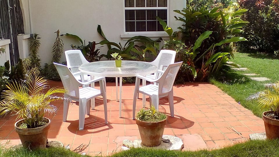 This patio overlooks overlooks a garden & lawn. Relax here and enjoy a cocktail.