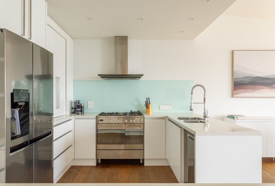 A fully-equipped kitchen including dishwasher, double oven, gas cooktop, coffee machine and more