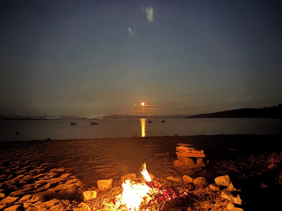 Bonfire and moonrise over the lake
