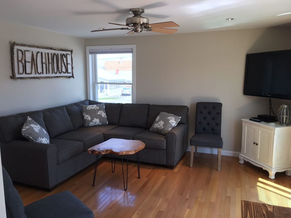 Living room with new sectional couch, 42" TV, DVD player, puzzles & games