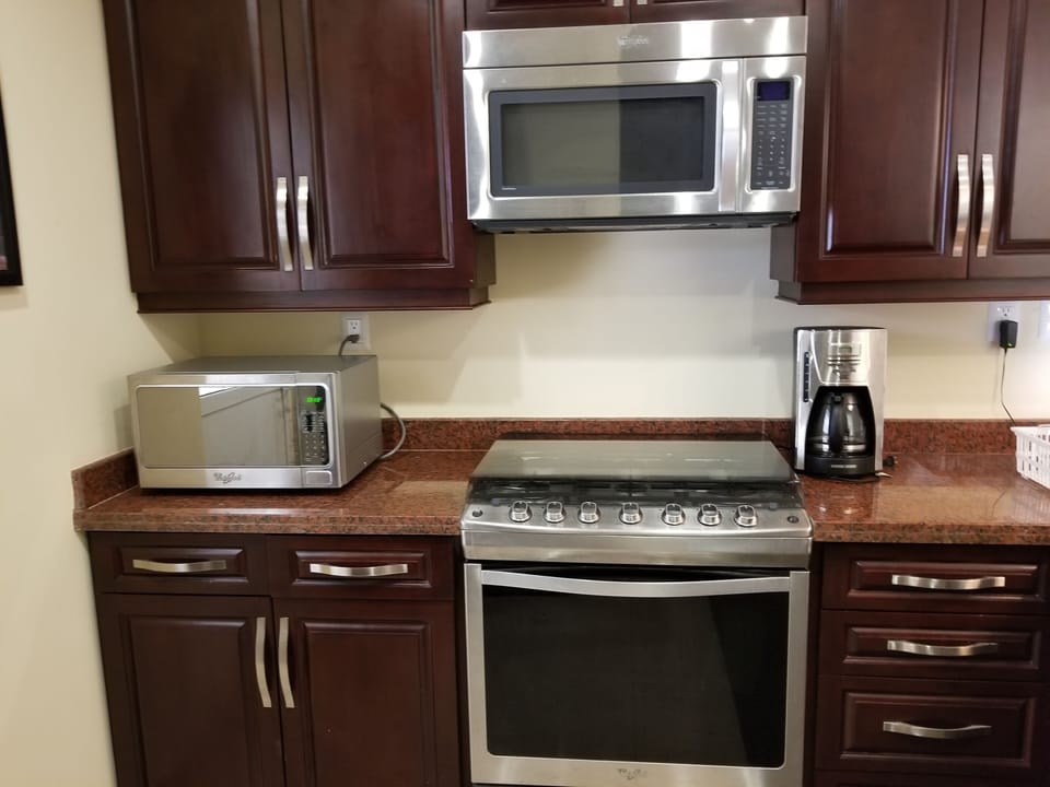 Modern kitchen well equipped with Whirpool appliances and granite counter top