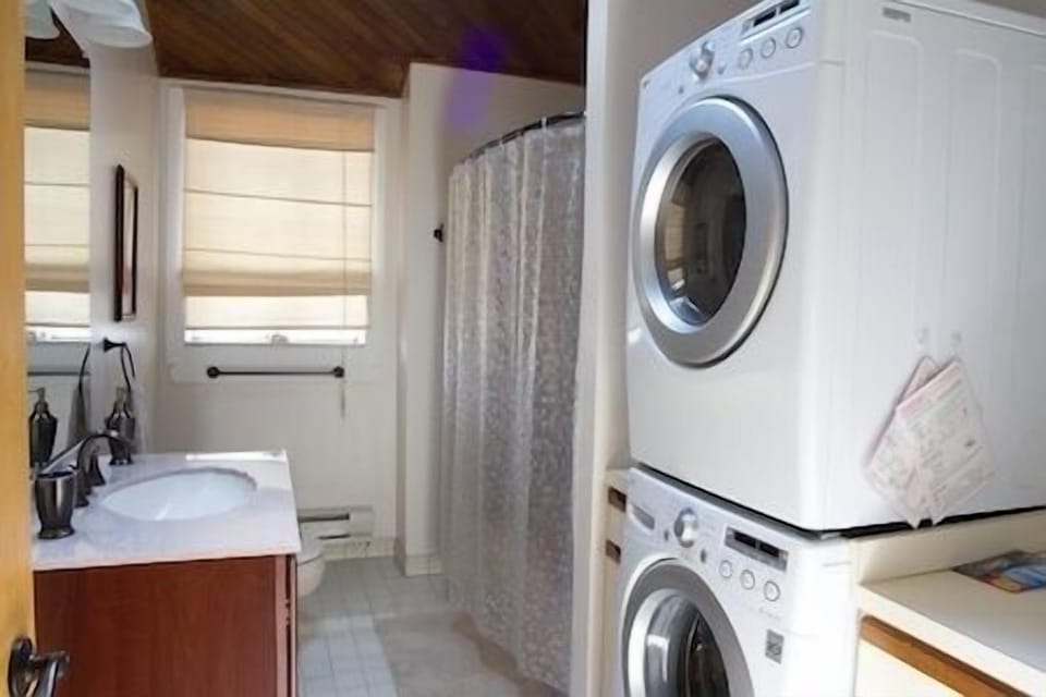Spacious Bathroom and Laundry combination with vaulted cedar ceiling, skylight, tile floor and garden window.