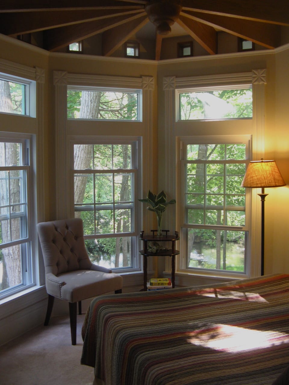 The ground floor bedroom is charming and looks out over Reed Creek and deck.