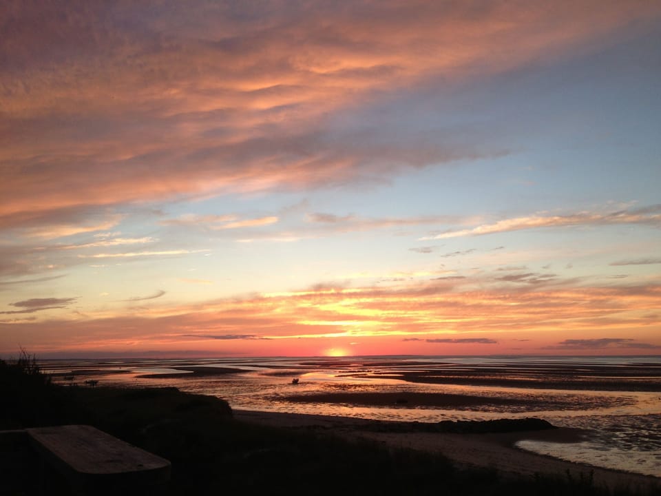 Sunset over Cape Cod Bay and sand flats from our bluff.