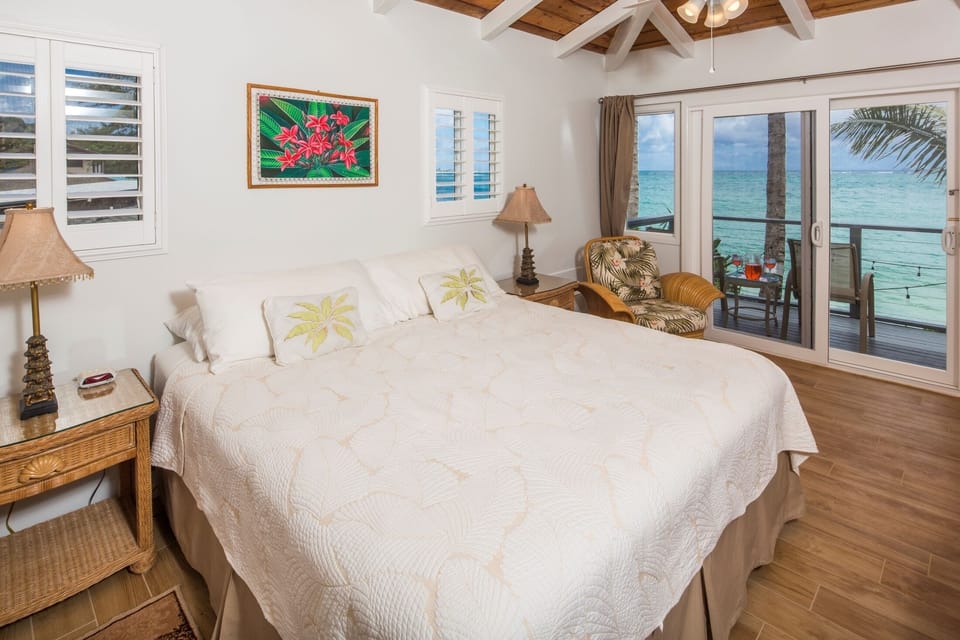 The master bedroom, featuring a Cal King bed, attached lanai & big ocean view.
