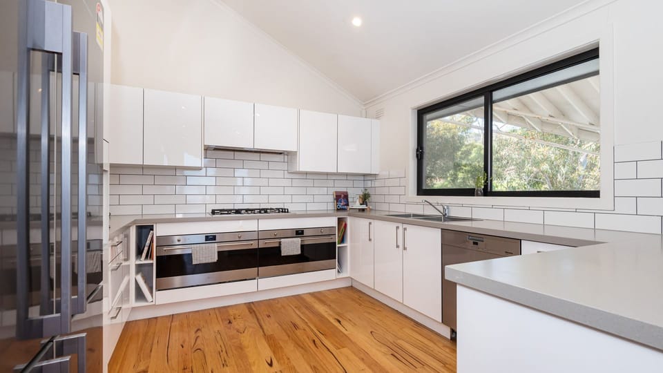 The kitchen, a chef's dream, features modern appliances and sleek countertops, providing ample space for meal preparation and culinary creations. 