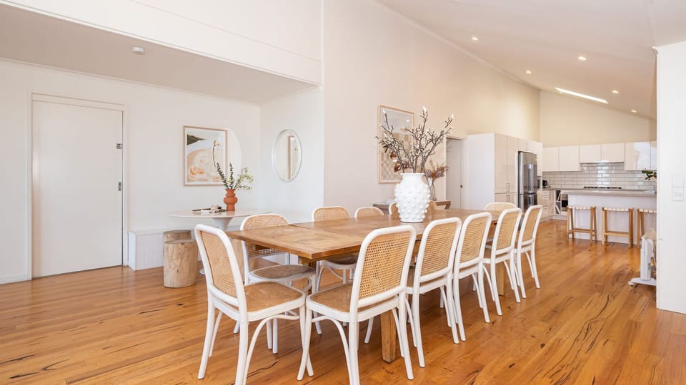 A spacious dining table takes center stage, adorned with tasteful decor.