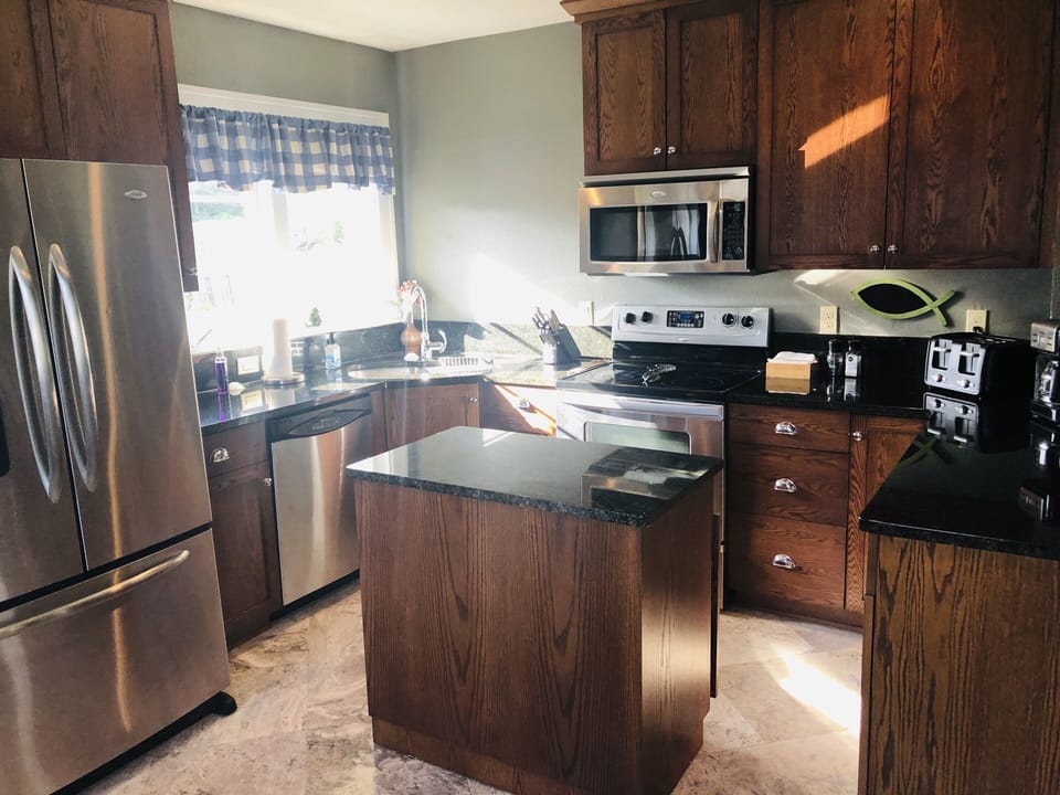 Oak Shaker kitchen cabinets with granite counter tops and floors