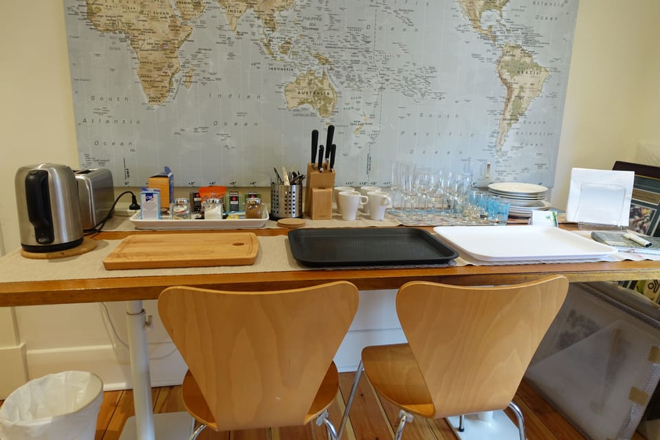 Kitchenette, crockery, cutlery, glasses, trays, knives, seats, table, kettle etc