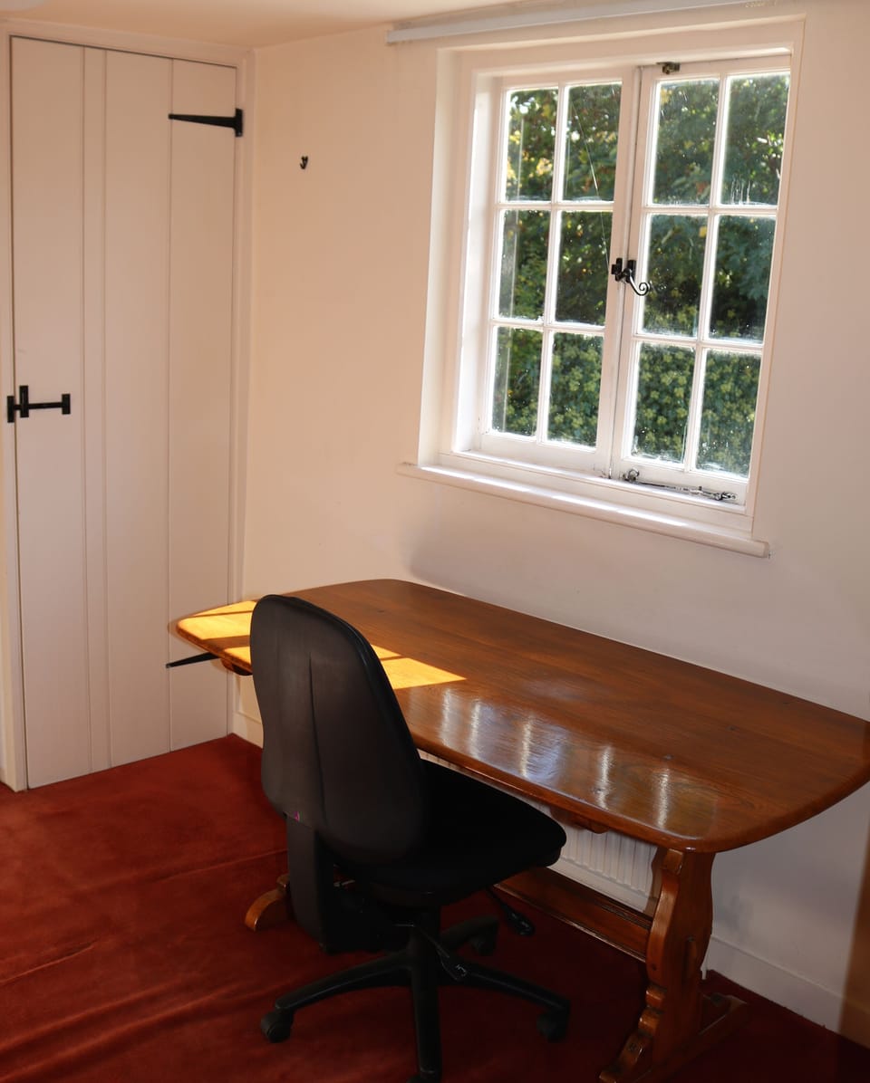 Office with desk at the window overlooking the garden