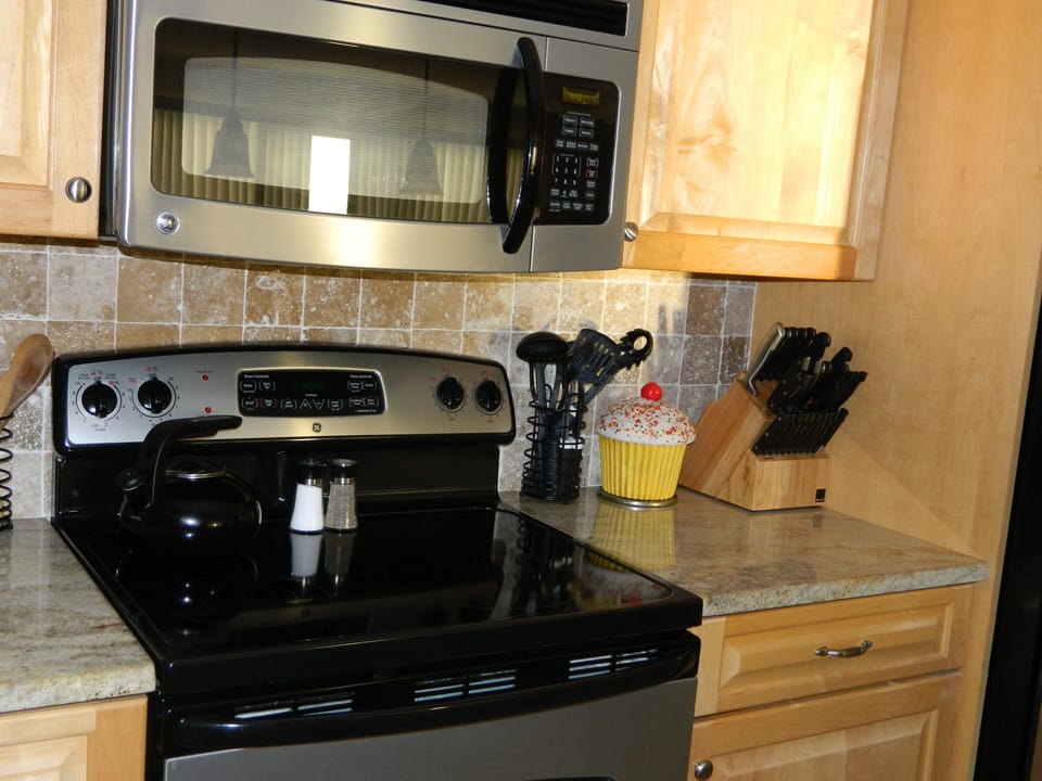 Stainless steel microwave and stove with granite counter tops.