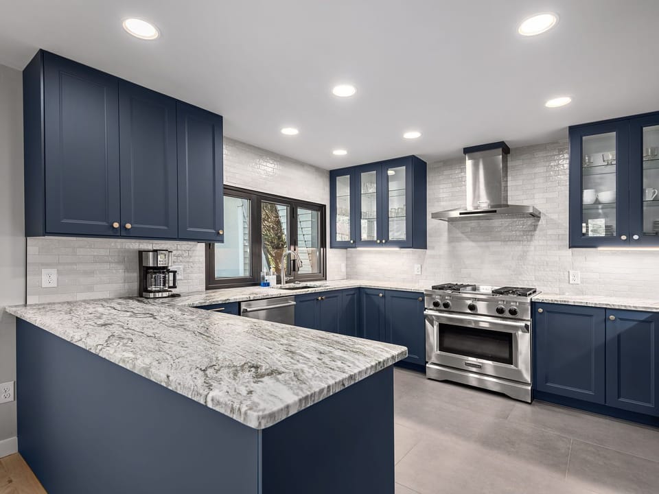 Open concept kitchen with granite countertops and stainless steel appliances.
