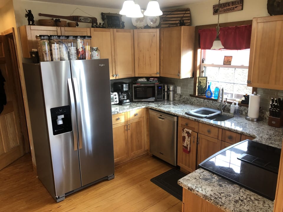 Kitchen has granite countertop, Jenn-Air range & stainless fridge with ice/water
