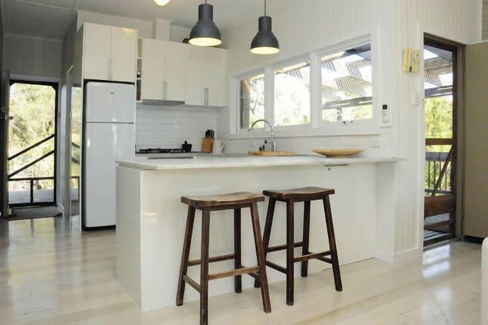 Kitchen with view of entry door to the left and back deck to the right
