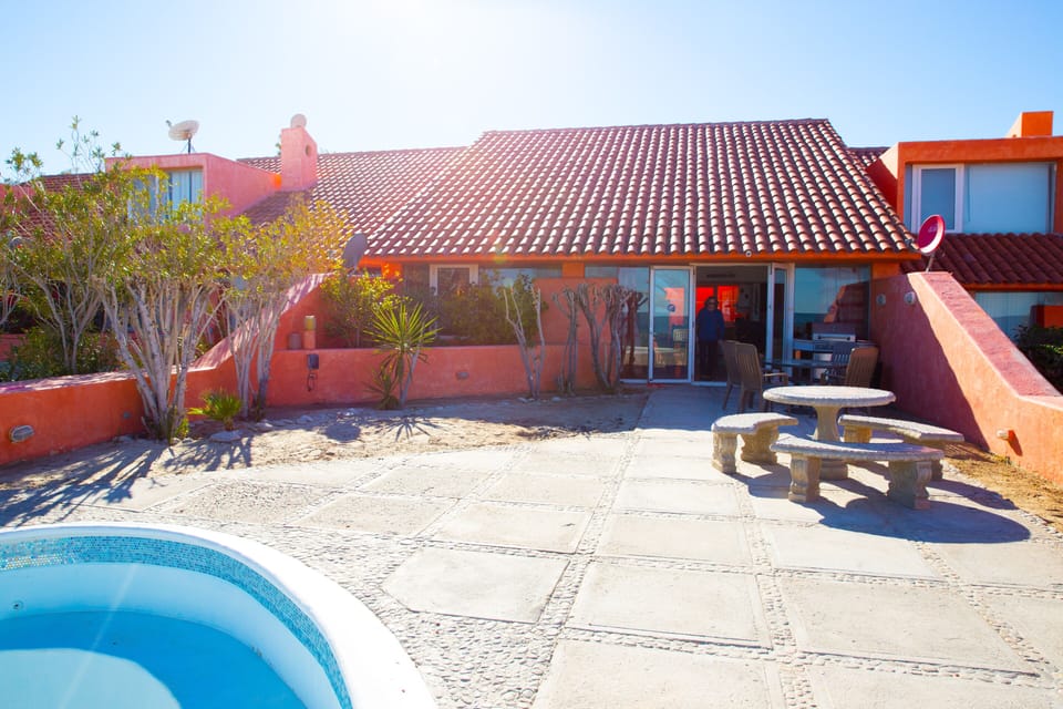 Back deck of the villa with outdoor seating, a pool, and a grill