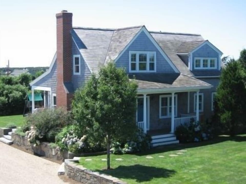 Front view. The backyard has a swingset and shed with an outdoor shower