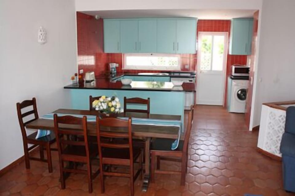 Dining table and attractive new kitchen with door to veranda with BBQ