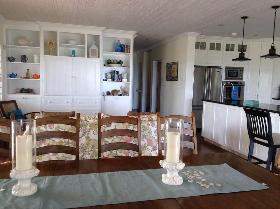 View of tv/wall unit including dining table and couch 
