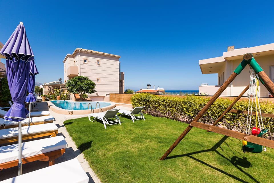 Fenced garden with flowers, sun beds, sun umbrellas, swimming pool, etc.