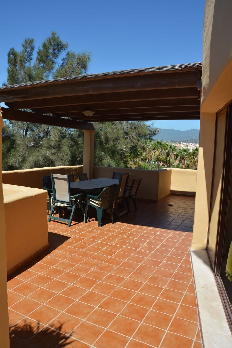 Second half of balcony with table and seating for eight under shelter from sun.