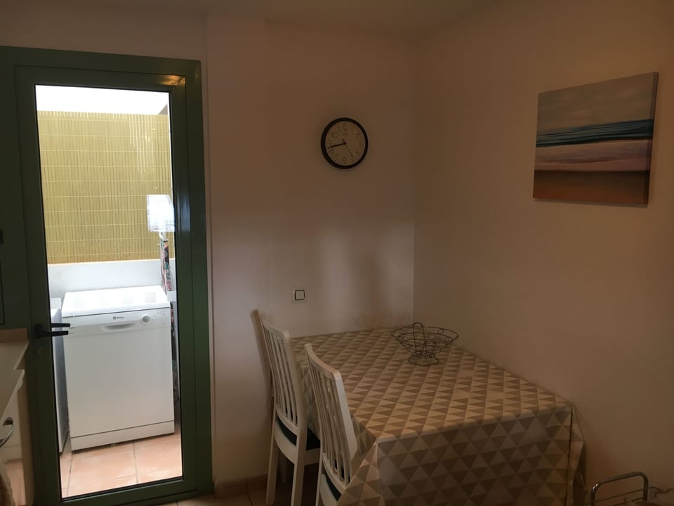 Kitchen with adjoining utility area and table seating up to 6 people.