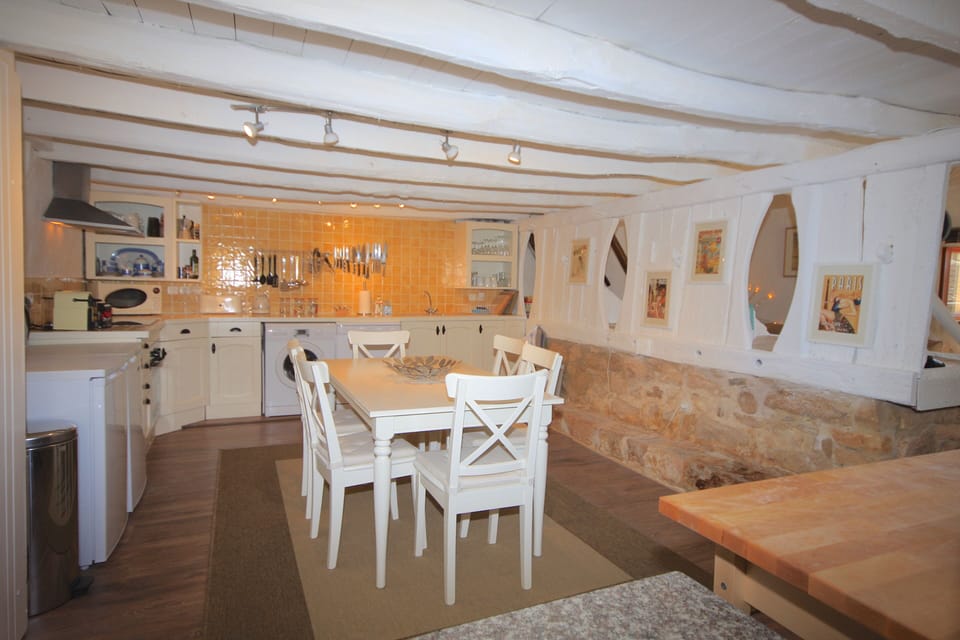 Kitchen/diner with whitewashed beams and traditional cattle stalls
