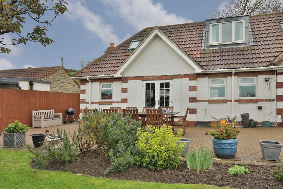 Large patio with table and chairs and charcoal bbq