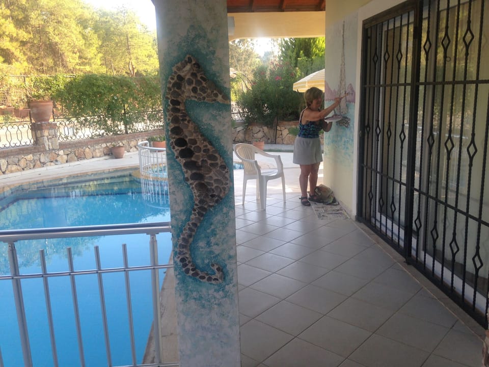 Creating a pebble mural. A bamboo fence has since been erected for added privacy