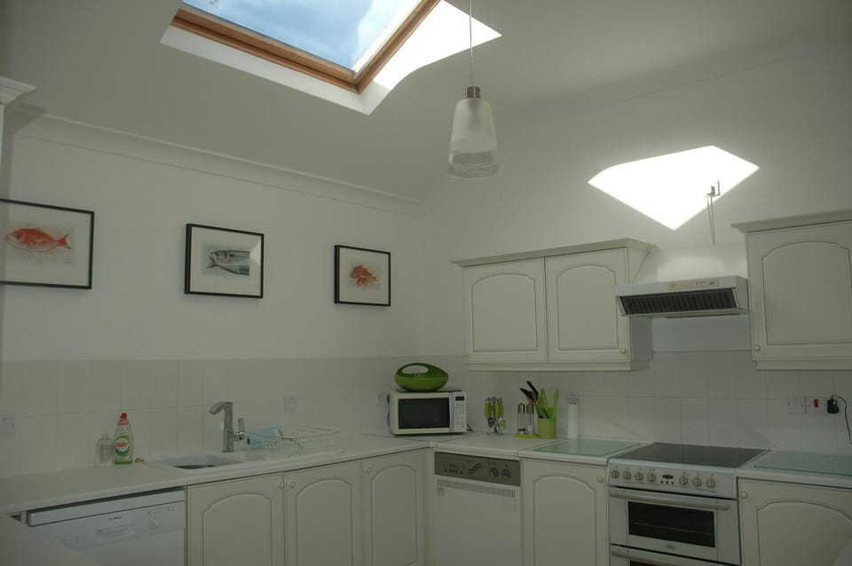 large sunny kitchen with utility room next door