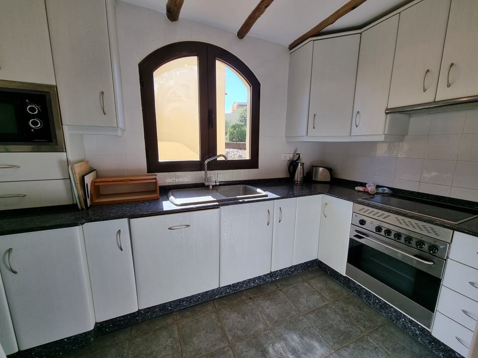 Kitchen with oven, hob, fridge freezer and microwave. Well stocked cupboards