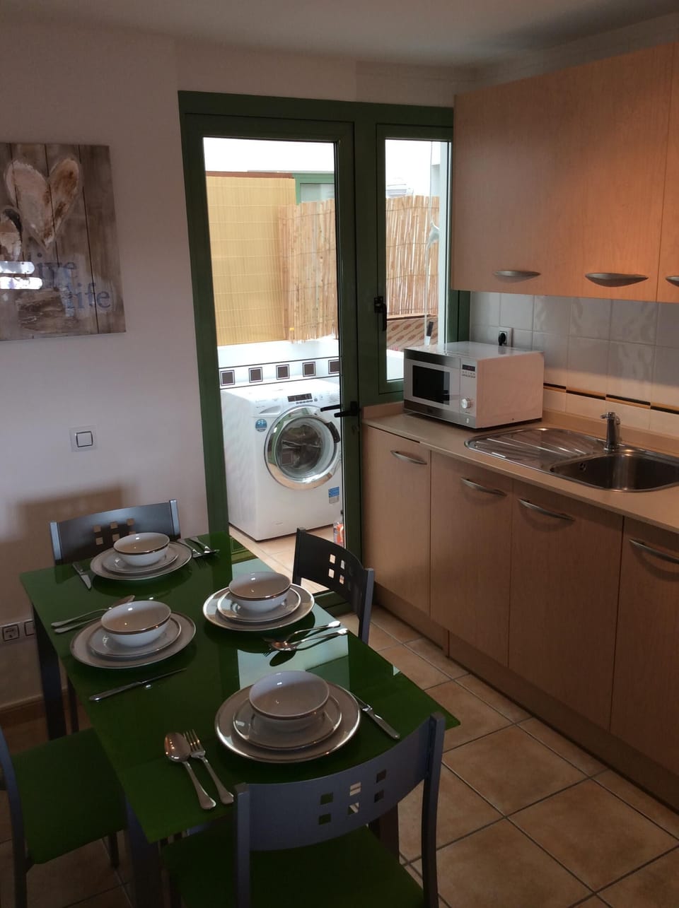 Fully fitted kitchen with table and chairs and  door into utility roo