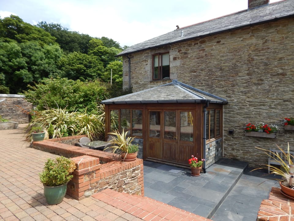 At the front of the property, a slate covered patio has high-quality furniture