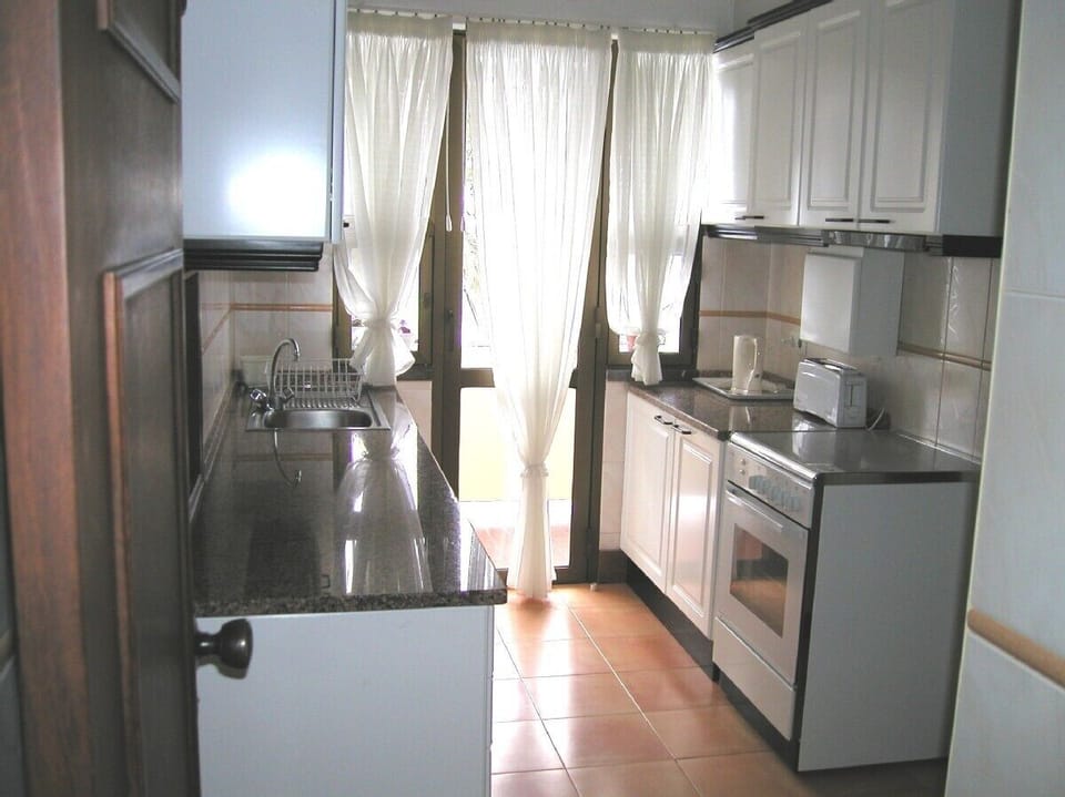 Kitchen with glass doors onto another balcony