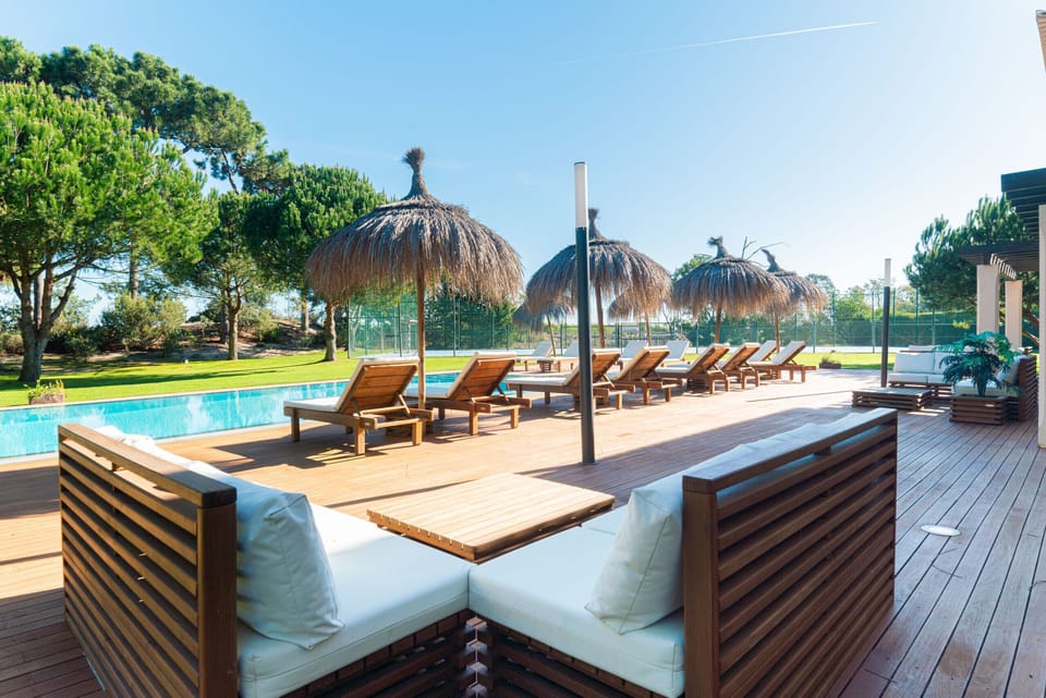 Luxury pool deck with loungers and thatched umbrellas — Villa Aqua, holiday villa in Grândola